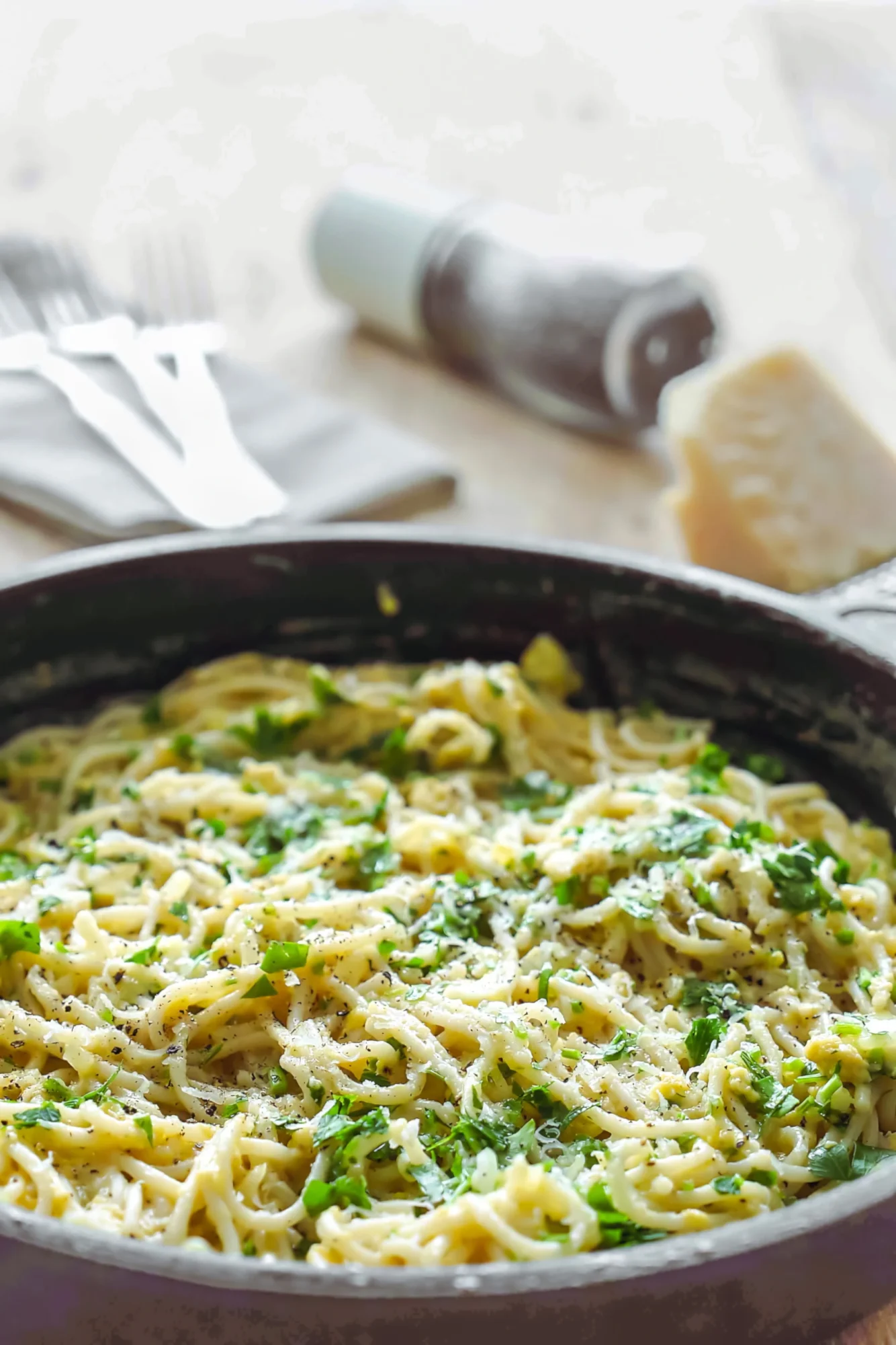 Cremige Knoblauch-Pasta mit Parmesan, Ei und frischen Kräutern in der Pfanne.