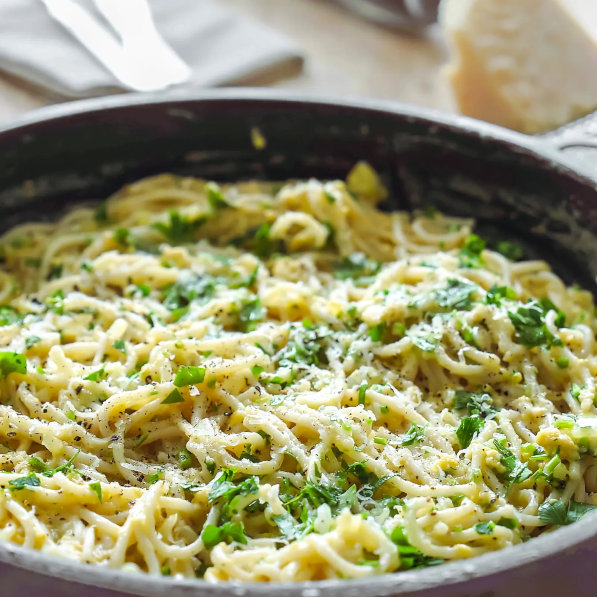 Cremige Knoblauch-Pasta mit Parmesan, Ei und frischen Kräutern in der Pfanne