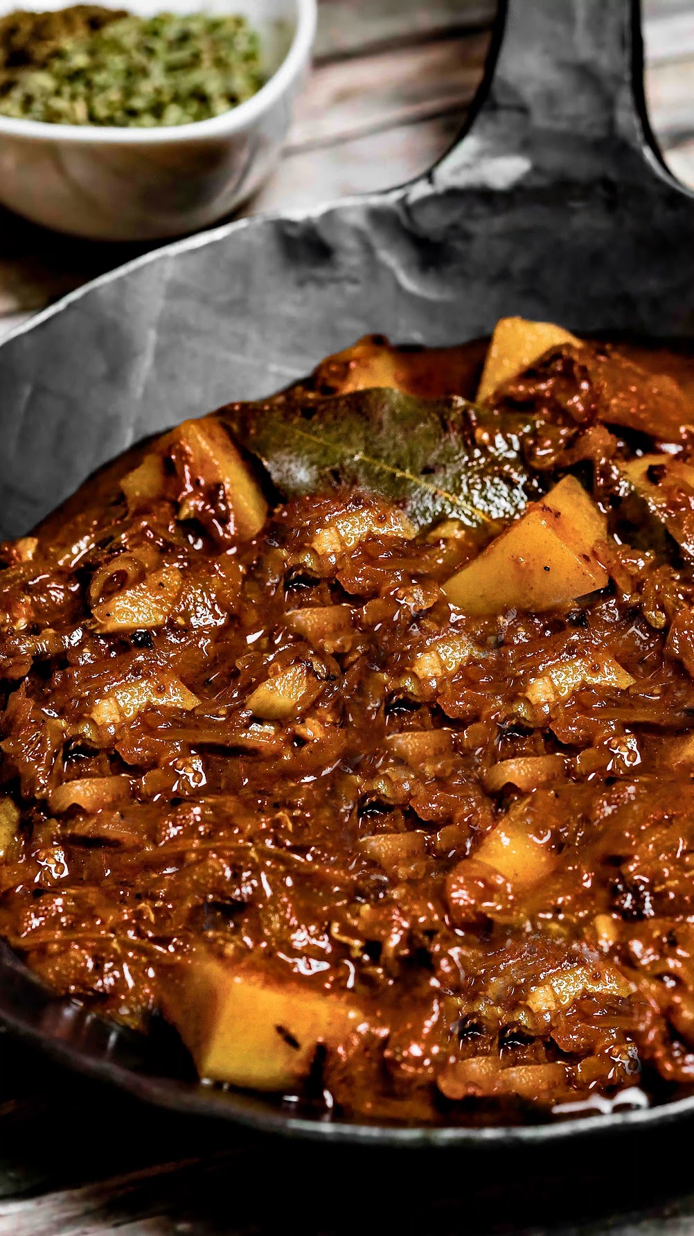 Steirisches Kartoffel-Sauerkraut-Gulasch in einer Eisenpfanne fertig zubereitet angerichtet